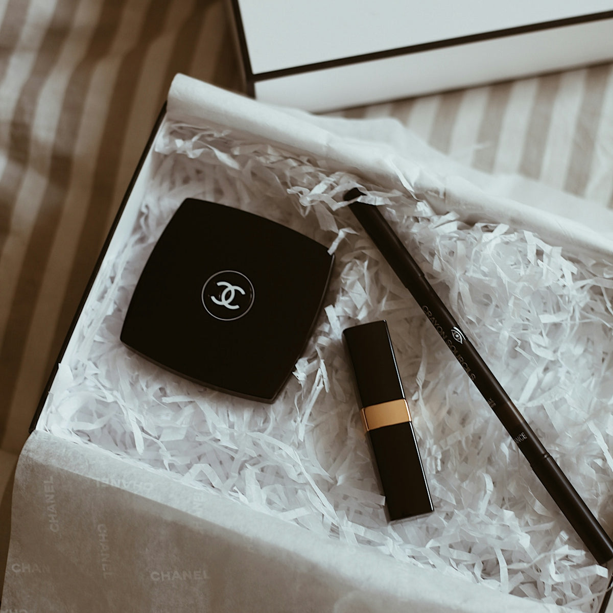 A chanel box with a pen and a watch