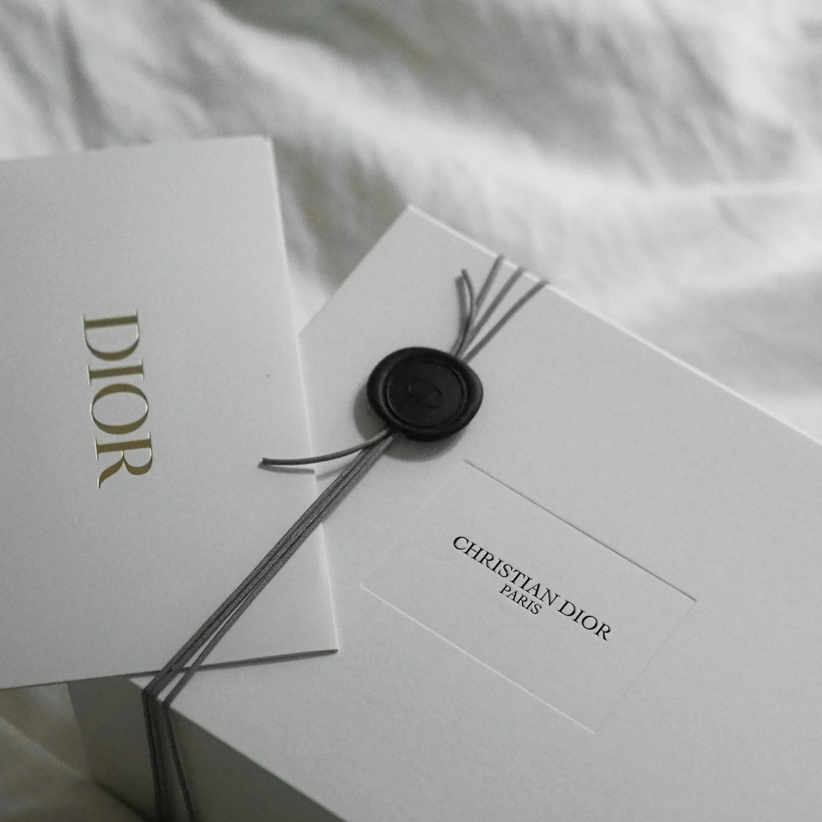 Dior gift box with wax seal and ribbon.