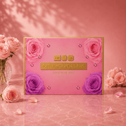A pink and gold Pat McGrath Labs Exclusive Edit box decorated with pink and purple roses, set on a pink marble surface with pink roses in a vase.